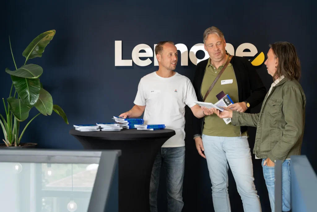 Een deelnemer krijgt het boek van Frans van Leeuwen met LemonPress-boekenlegger aangereikt