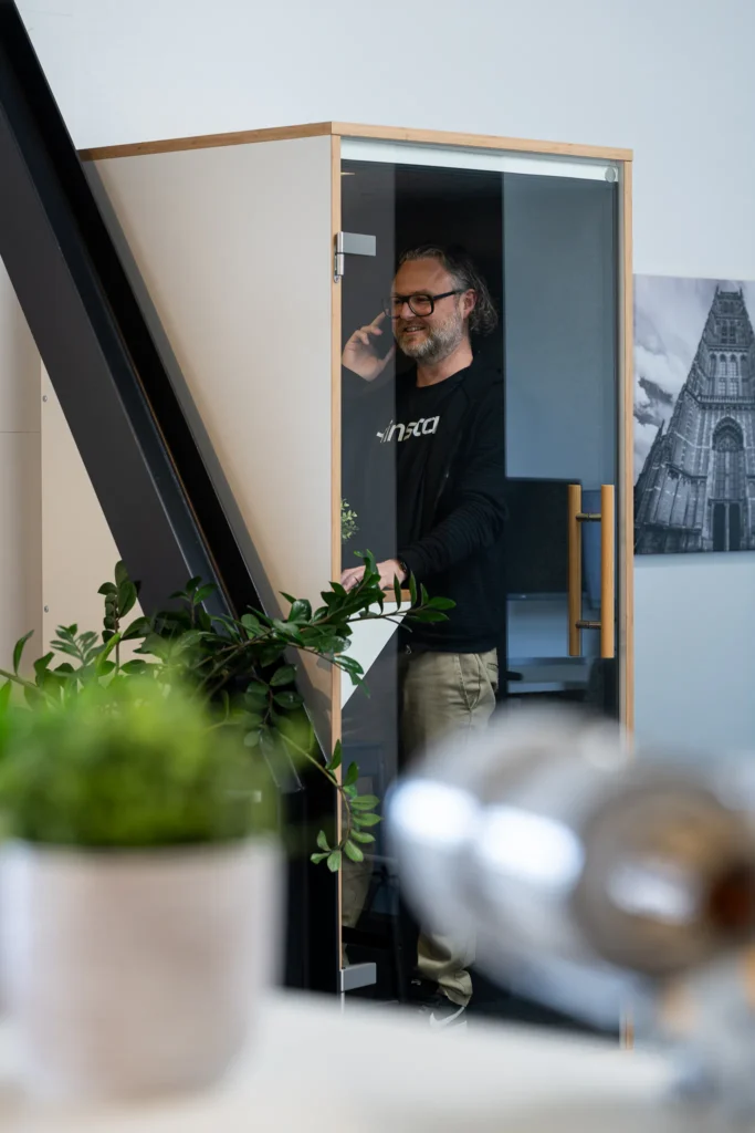 Collega staat te bellen in de telefooncel van het Lemone-kantoor